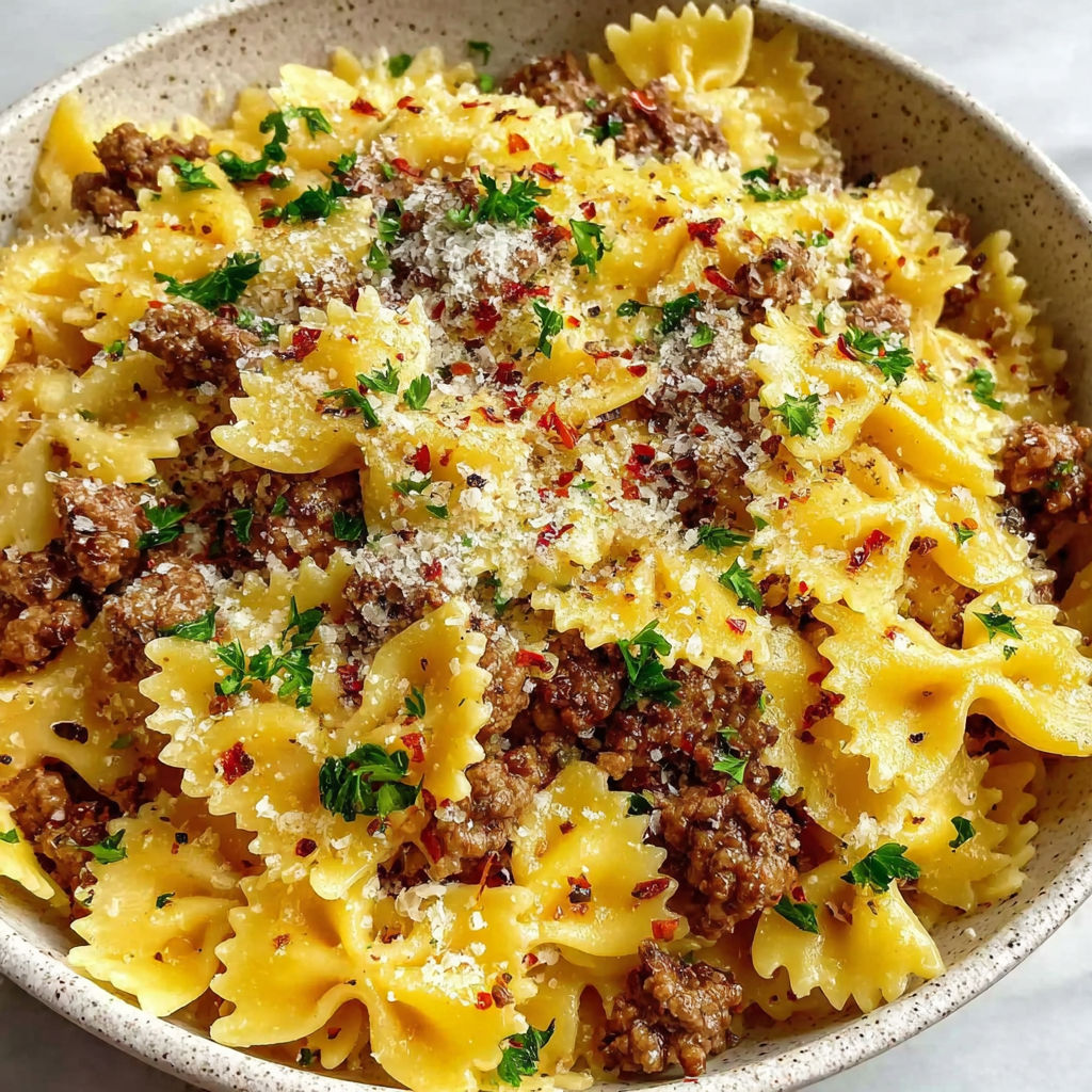 A bowl of pasta with meat and cheese.