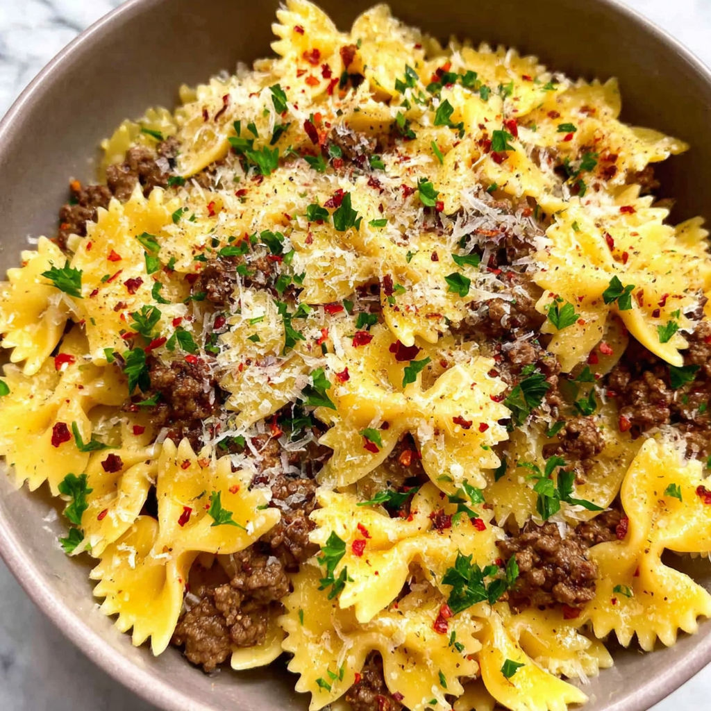 A bowl of pasta with meat and cheese.
