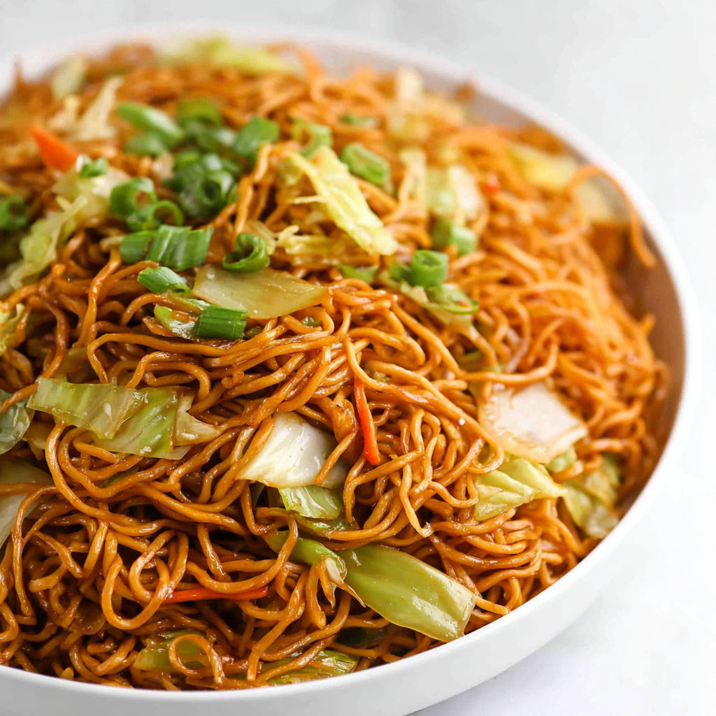 A bowl of chow mein noodles with vegetables.