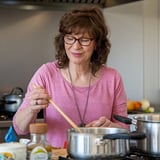 A woman cooking in a kitchen.