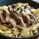 A bowl of creamy steak pasta.