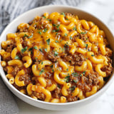 A bowl of chili mac with noodles and meat.