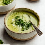 A bowl of soup with broccoli and potatoes.