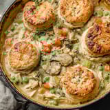 A close up of a chicken pot pie with biscuits.