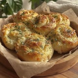 A plate of garlic rolls with cheese.