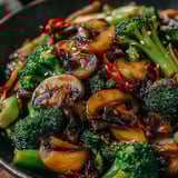 A bowl of stir fry with broccoli and mushrooms.