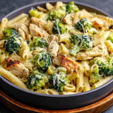 A plate of pasta with chicken and broccoli.