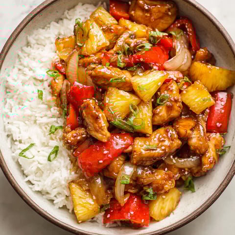 A bowl of pineapple chicken with rice.