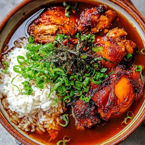 A bowl of food with rice, chicken, and ginger.